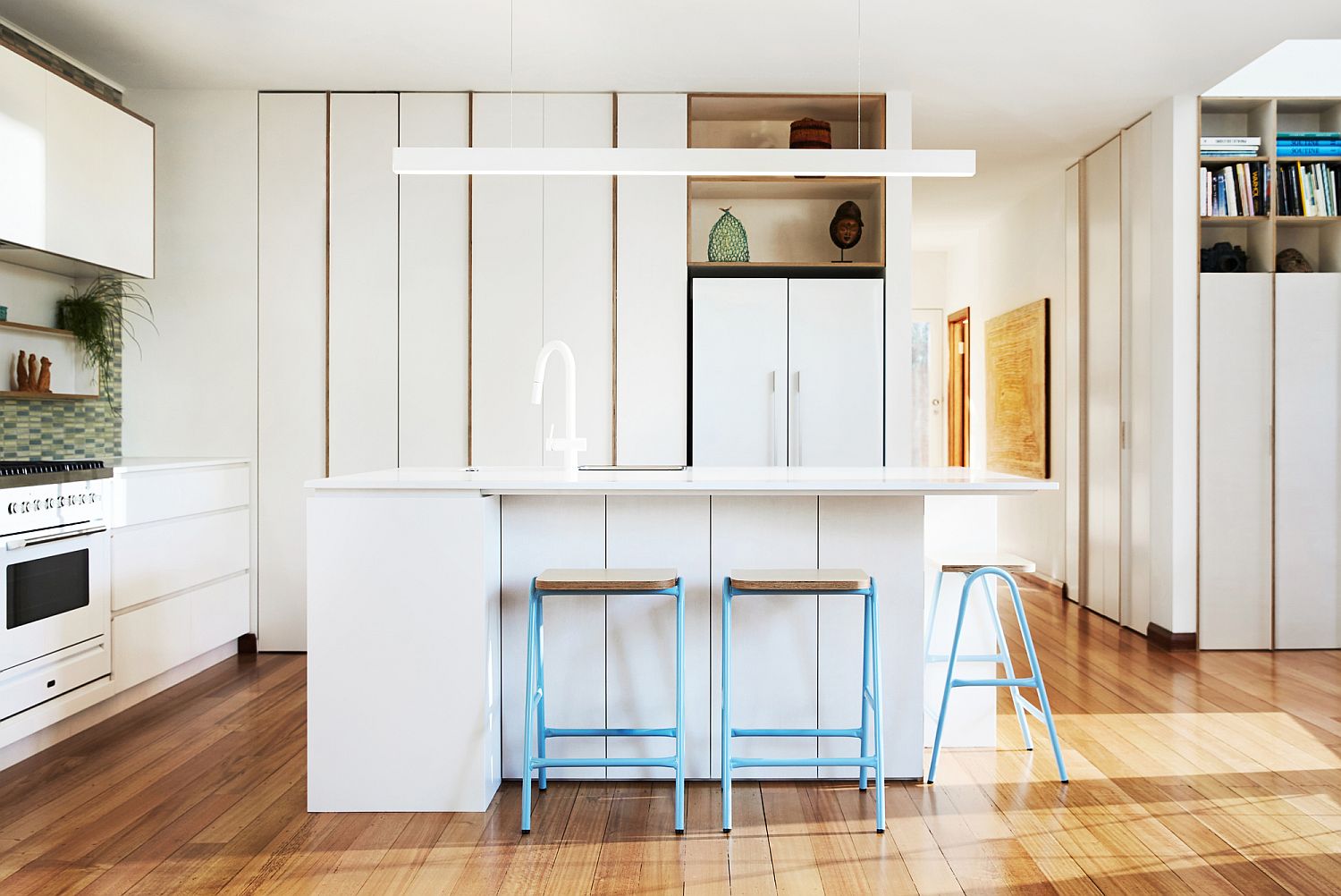 It is the flooring that brings wood to this contemporary kitchen in white