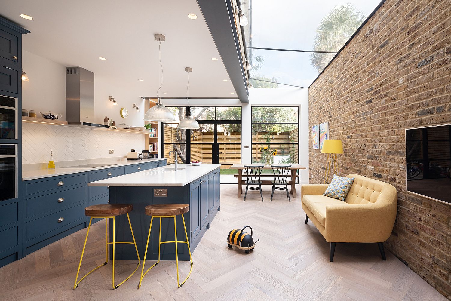 New kitchen and dining space with brick wall section and cabinets in blue