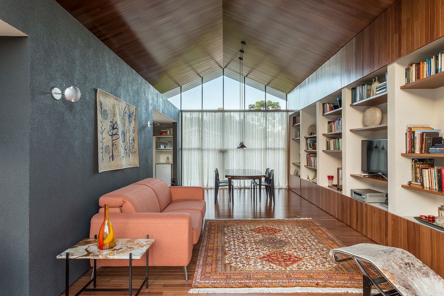 Pastel pink couch and ample shelving for the office interior