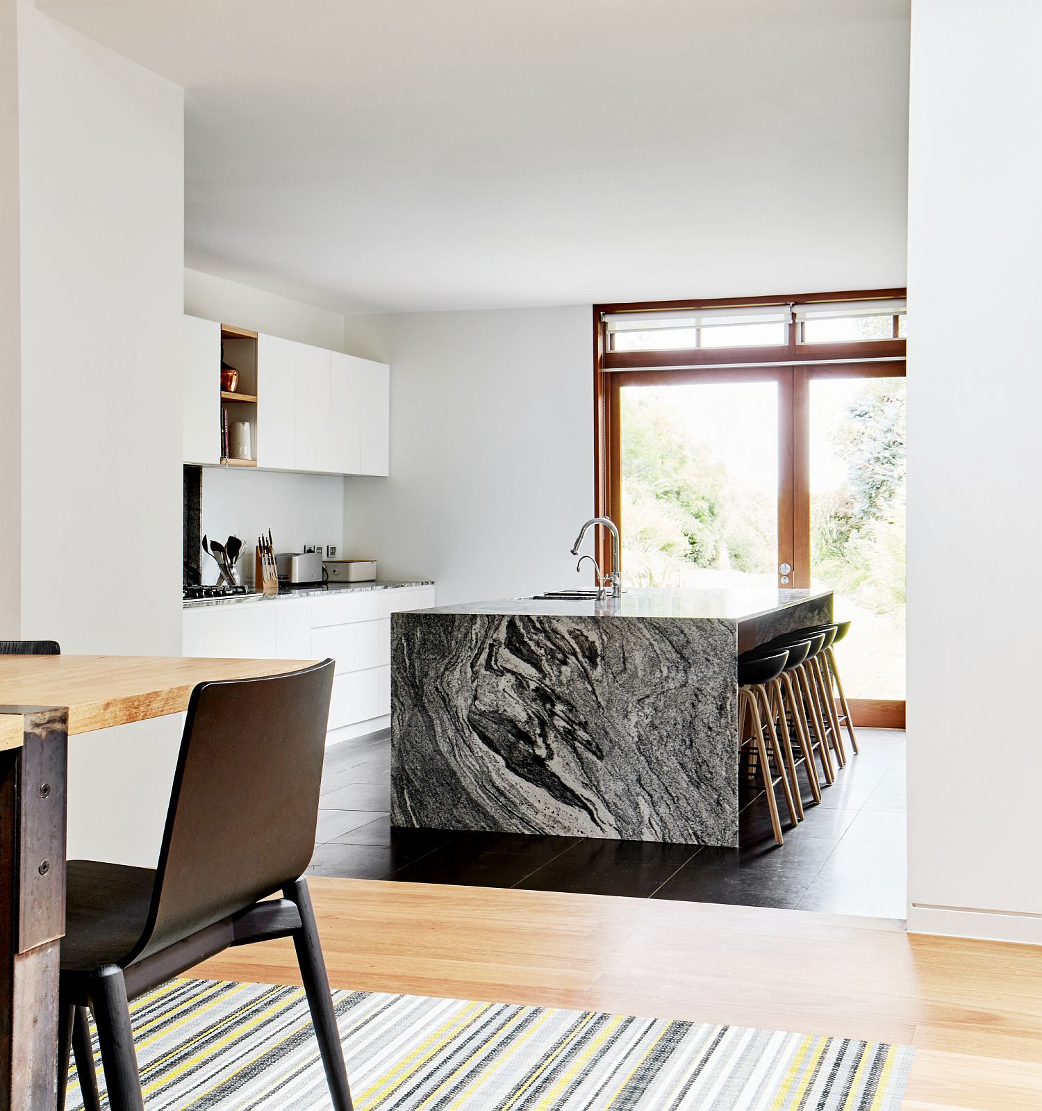 Stunning stone kitchen island steals the spotlight in this all-white kitchen