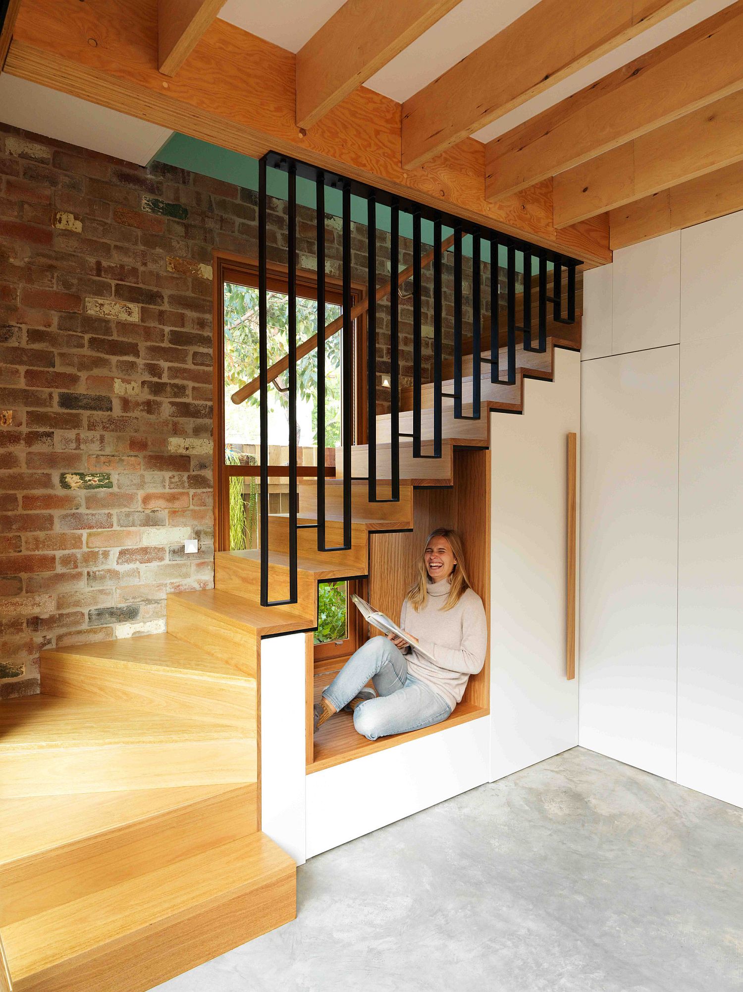 Tiny reading and sitting nook under the stairway