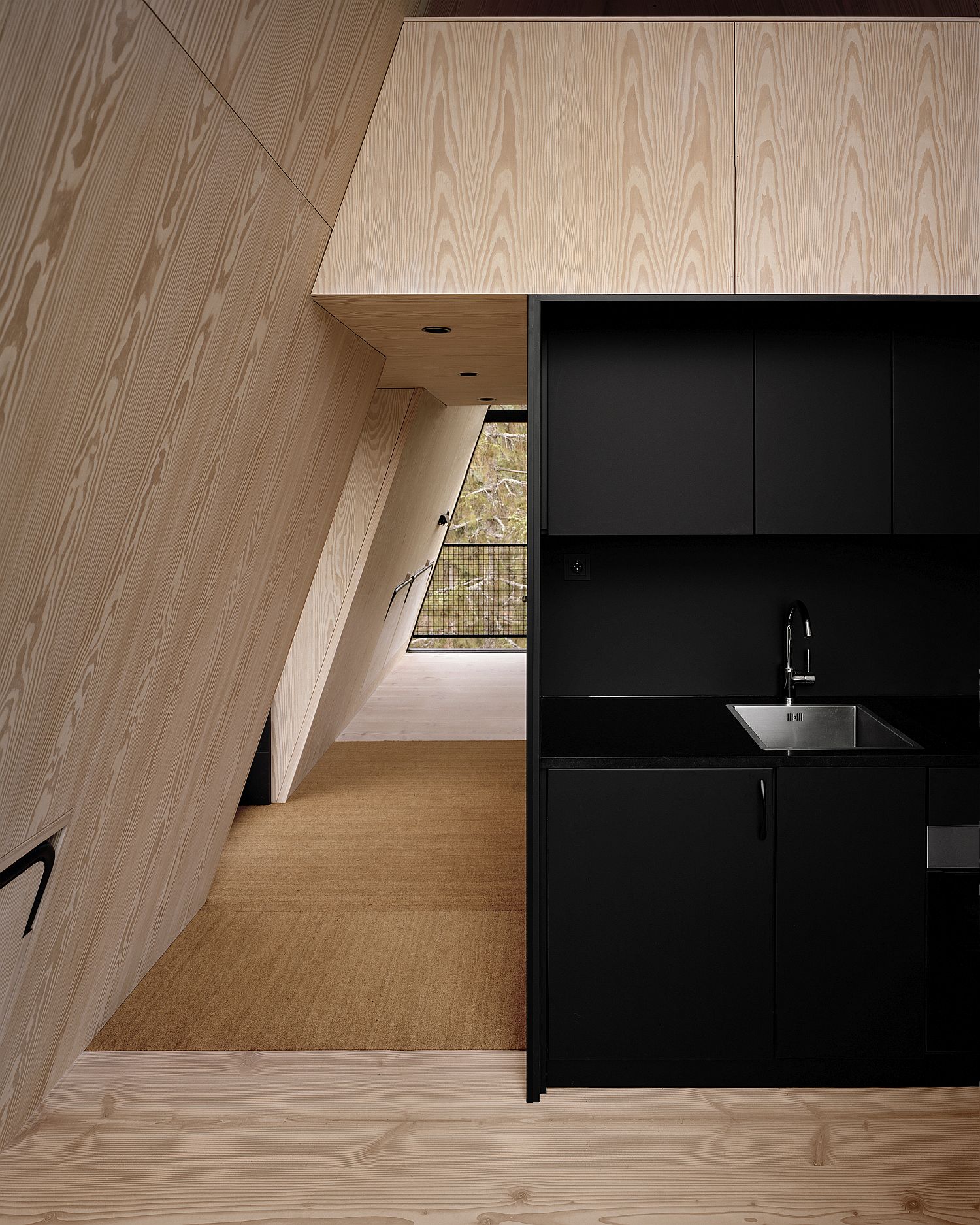 Black and wood tiny kitchen space inside the cabin