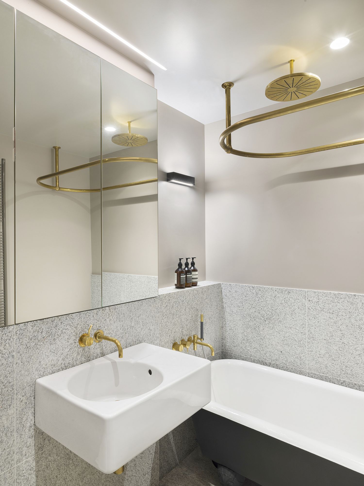 Brass fixtures add golden glint to the bathroom in white