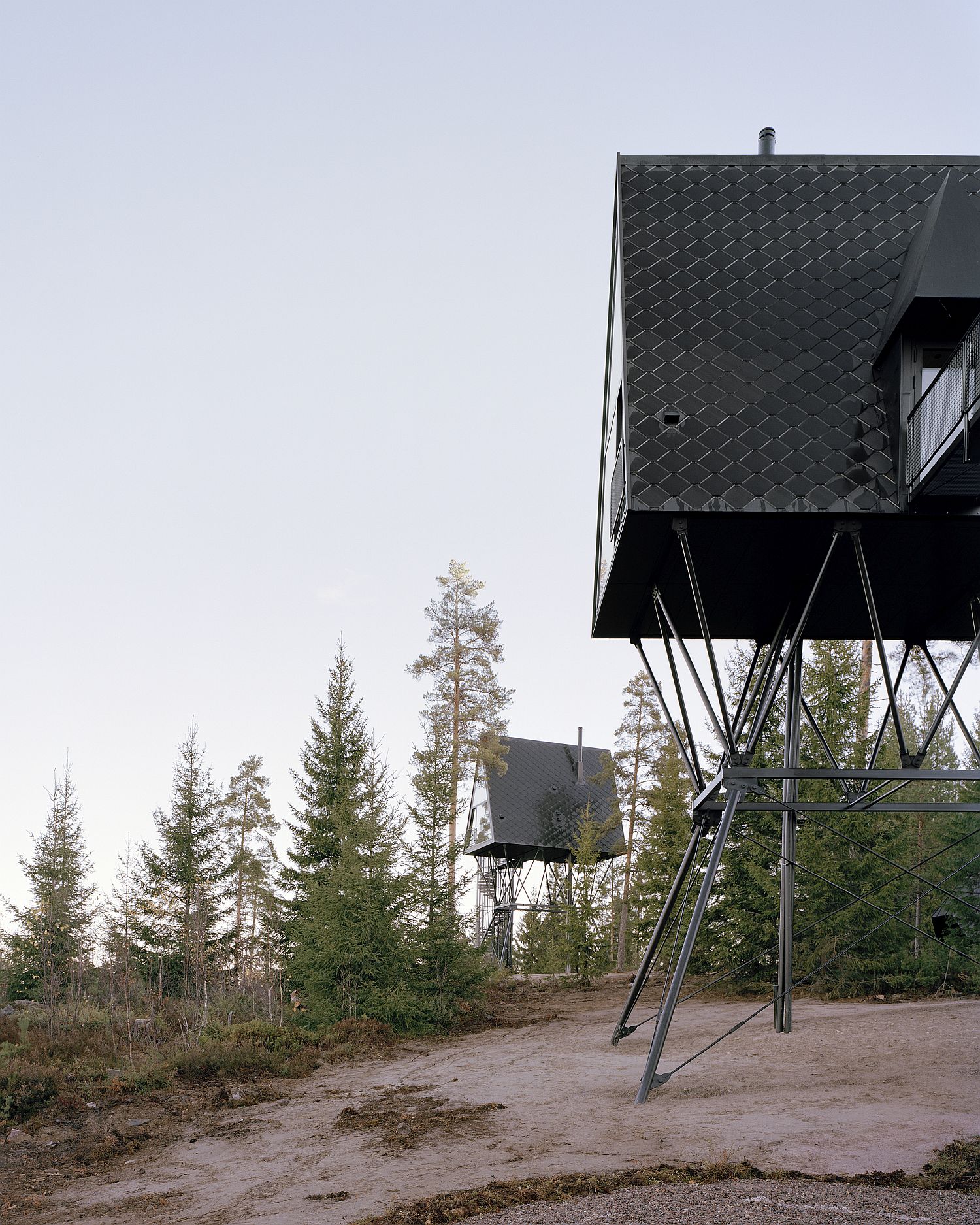 Modern cabin cantilevered above ground in the forest