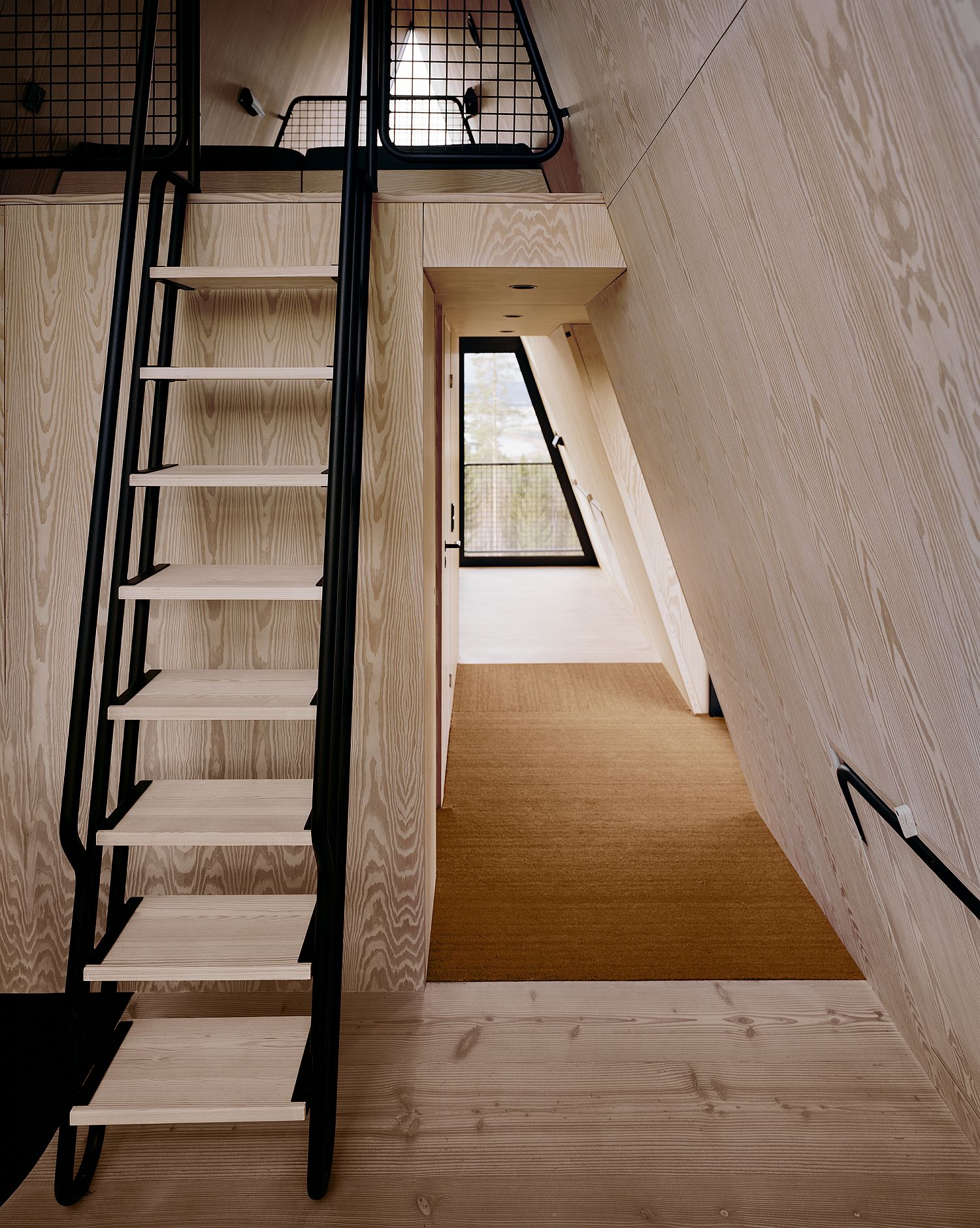 Natural wood and streel interior of the space-savvy forest cabin