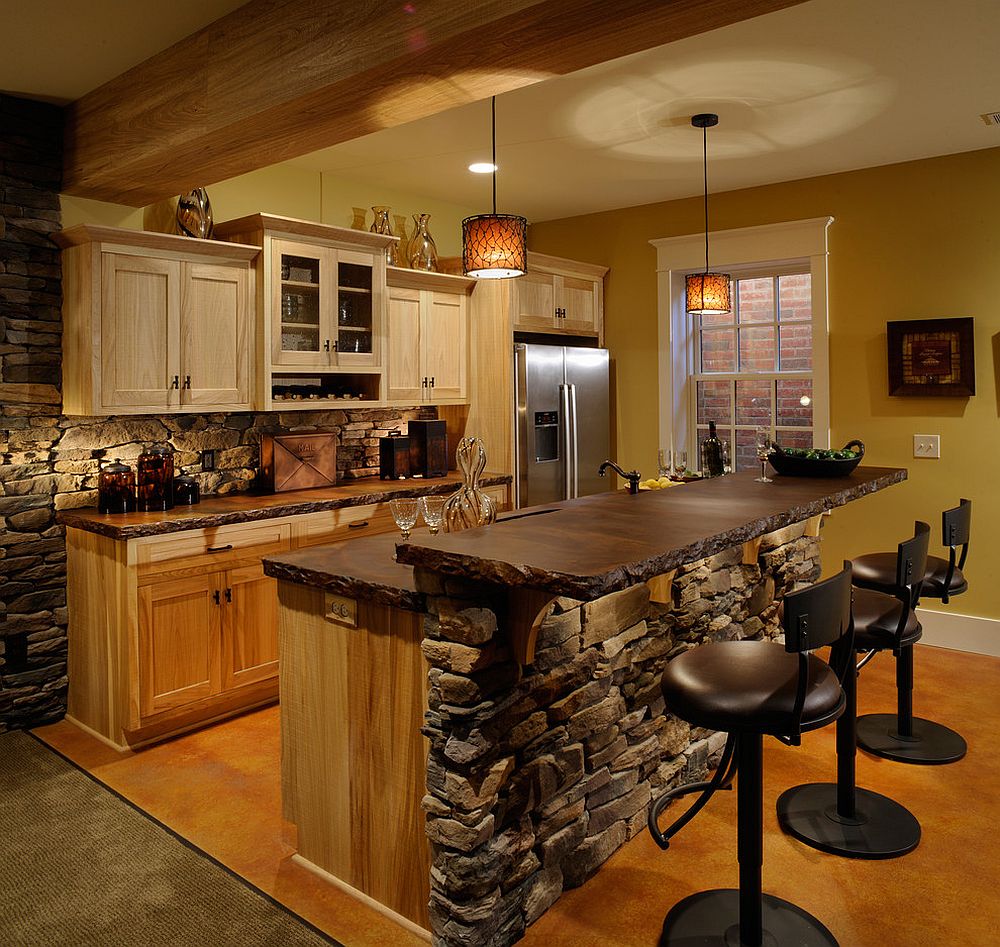 Rustic kitchen with stone walls and black bar stools