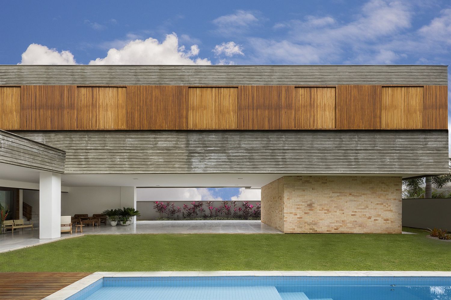 Sweeping yard and pool area of the L-shaped contemporary home in Brazil