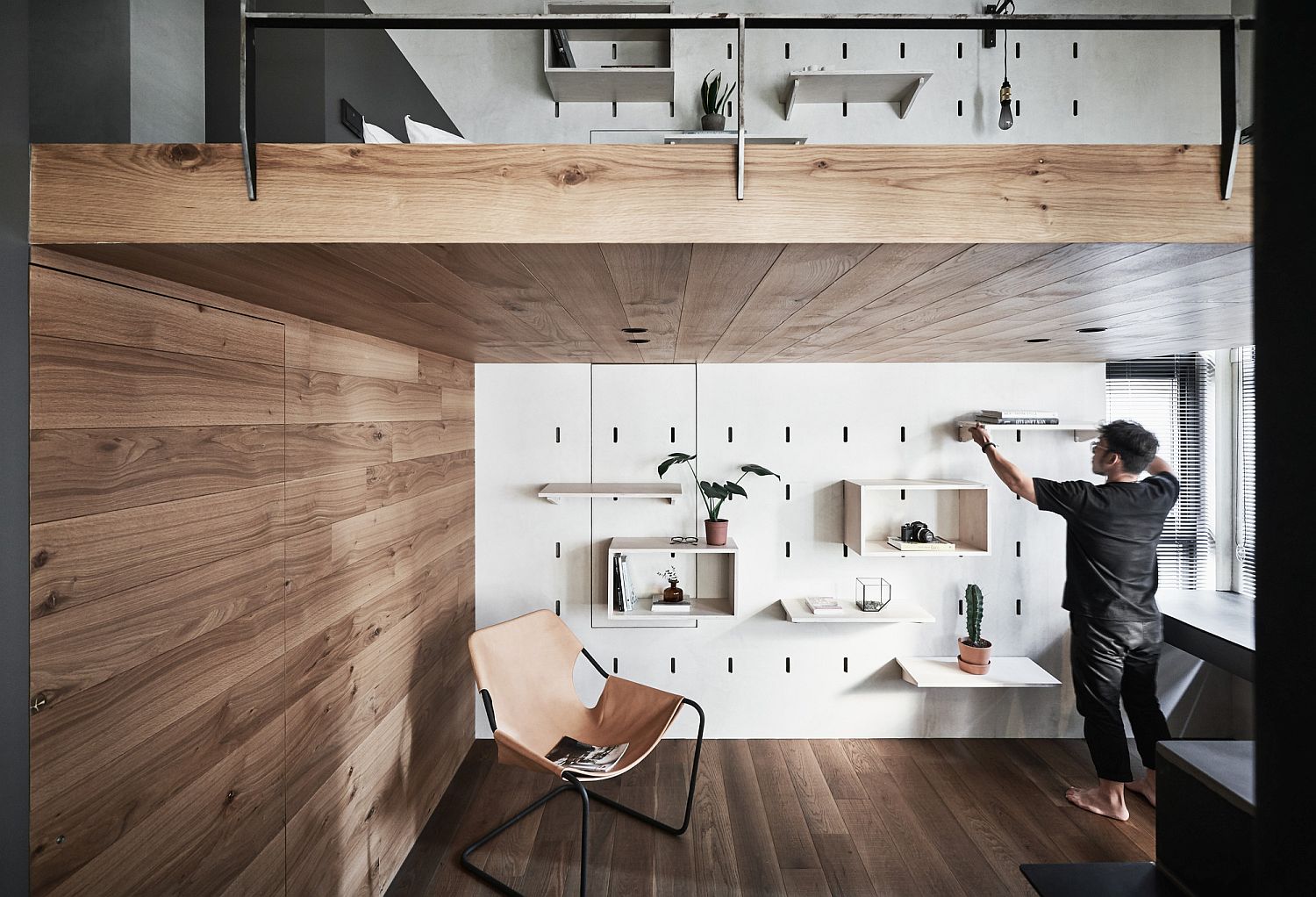 Tiny apartment with a smart mezzanine level and a cool storage wall