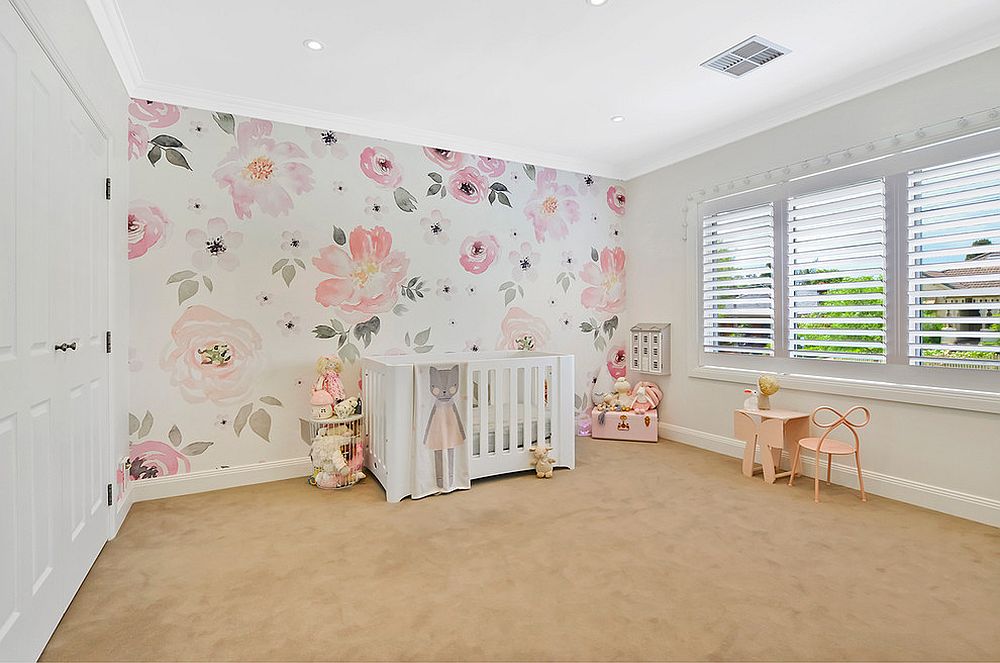 Wallpaper clad accent wall steals the show in this nursery