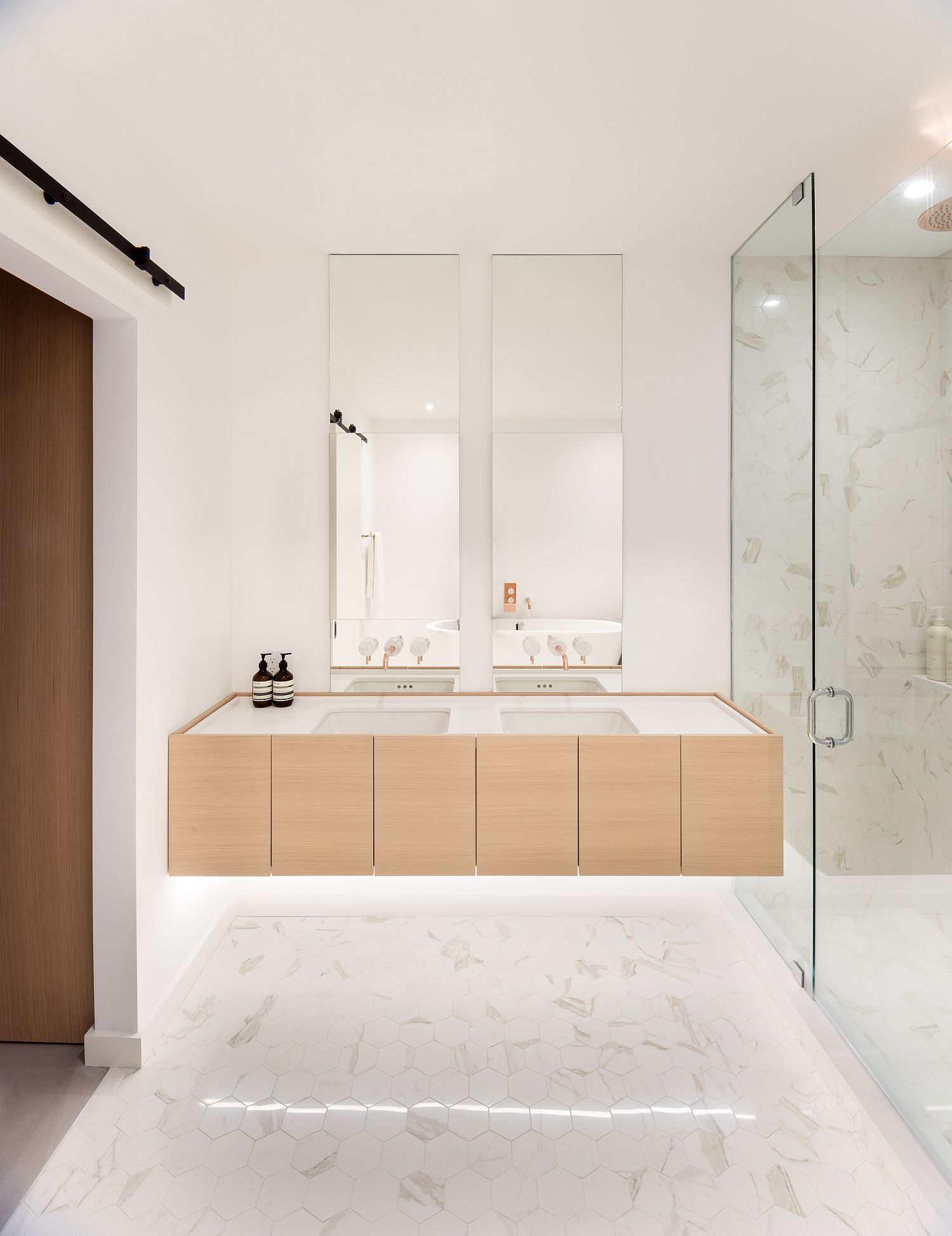 White-hexagonal-tiles-on-the-floor-add-subtle-pattern-to-the-curated-bathroom