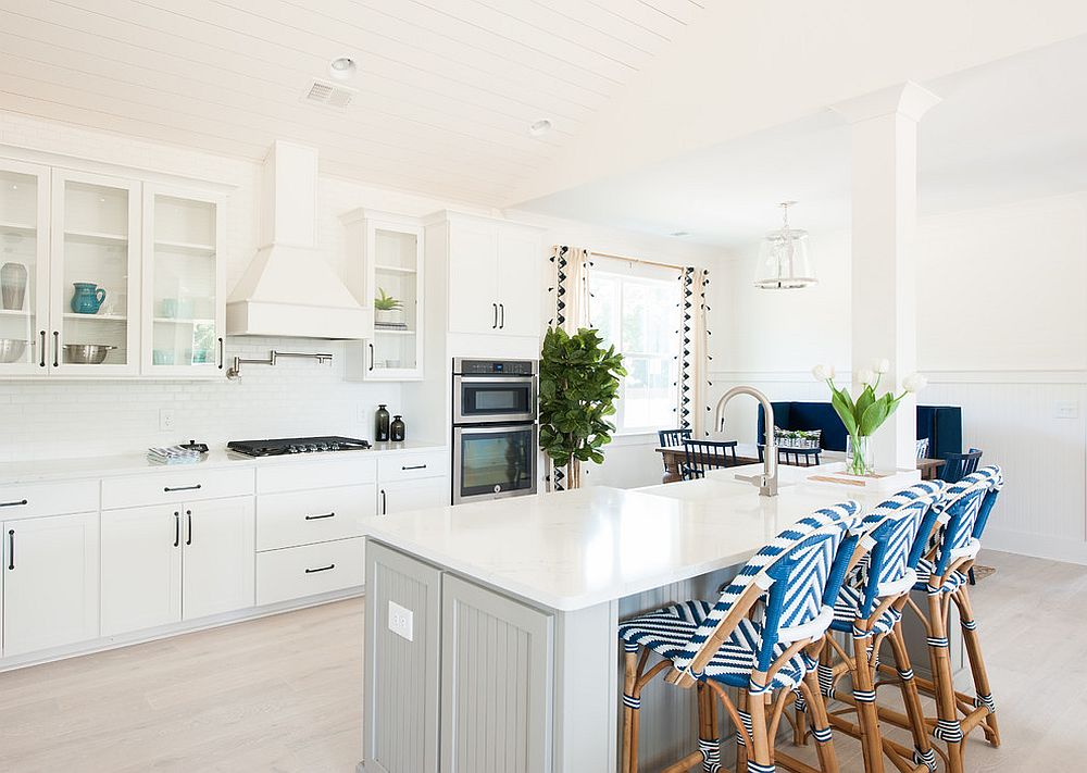 Bar chairs bring pattern to the all-white kitchen with relaxing beach style