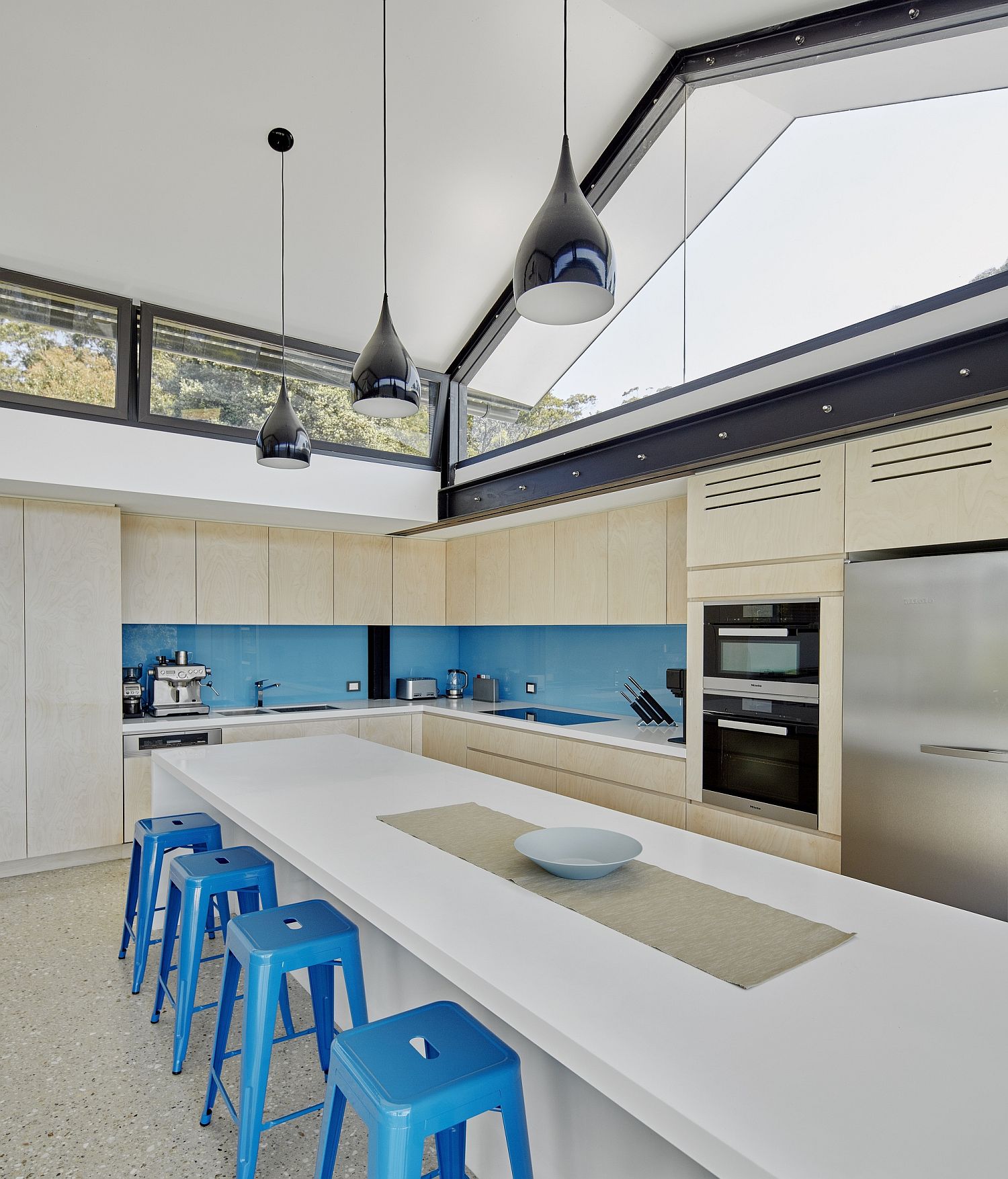 Bar stools and backsplash in blue for the spacious modern kitchen