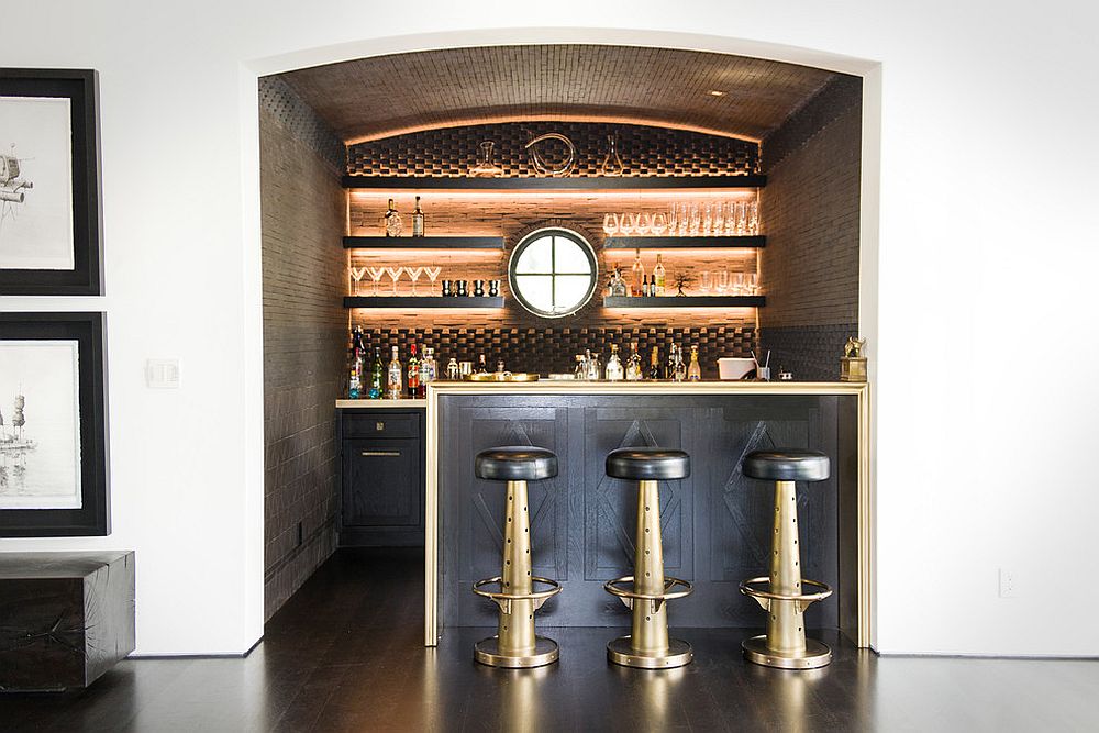 Beautifully lit shelves and backdrop create an exquisite home bar within a lovely little niche