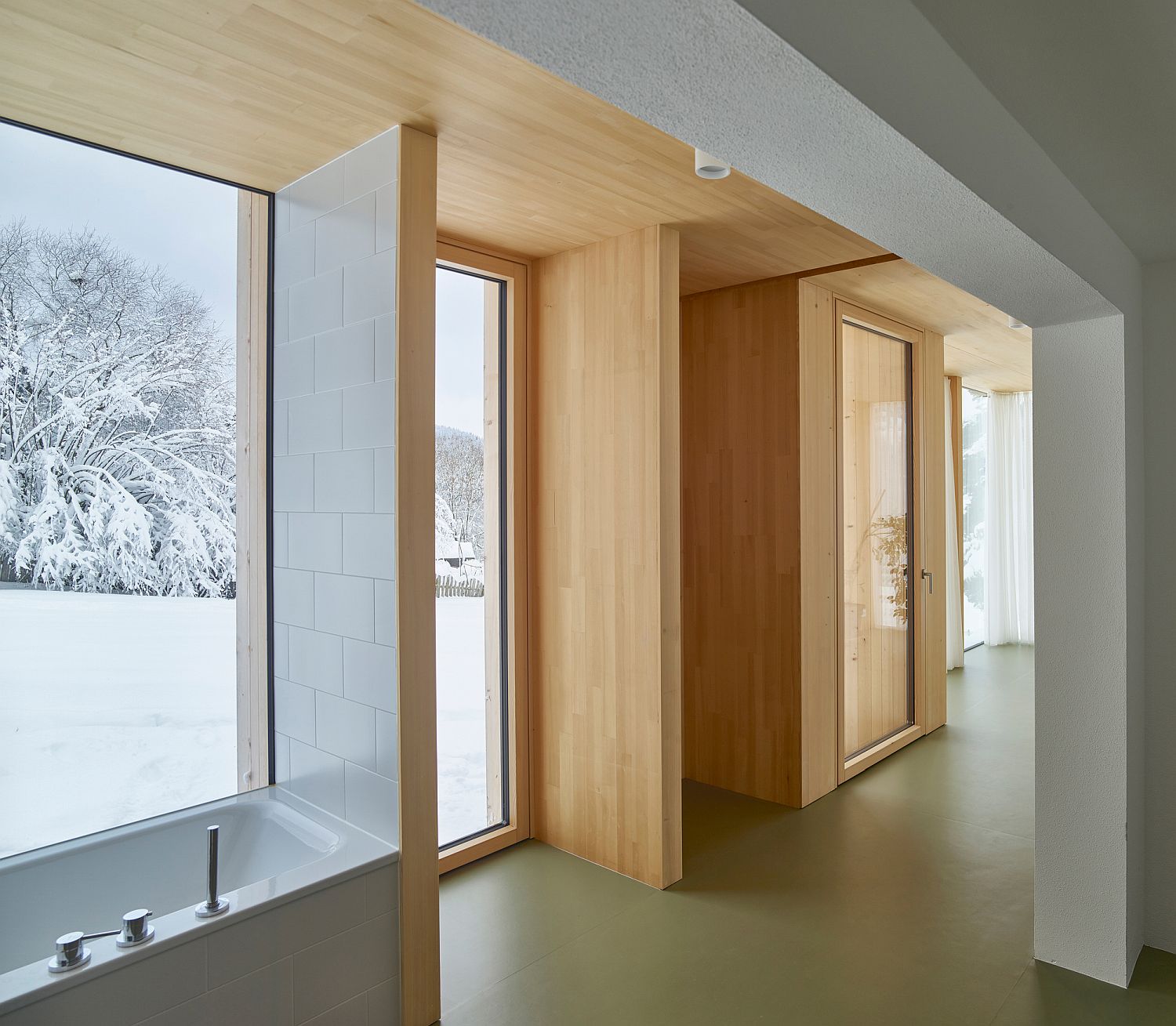 Floor-to-ceiling glass windows coupled with wood for the interior