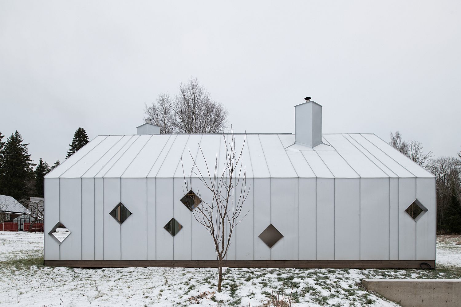 Gorgeous white modern sauna complex next to a farmhouse