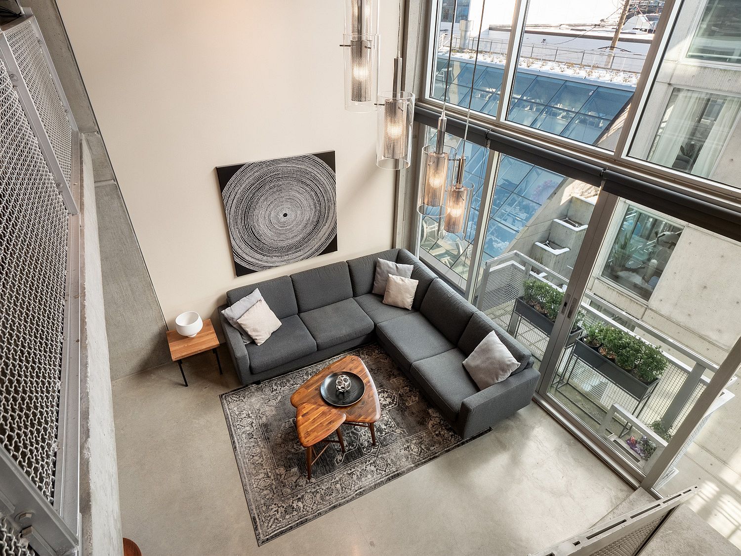 Gray sectional inside the living room fits in perfectly with its concrete-centric theme