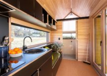 Kitchen-with-a-sitting-area-next-to-it-inside-the-tiny-cabin-home-217x155