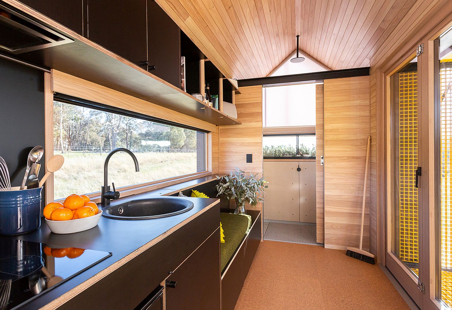 Kitchen with a sitting area next to it inside the tiny cabin home