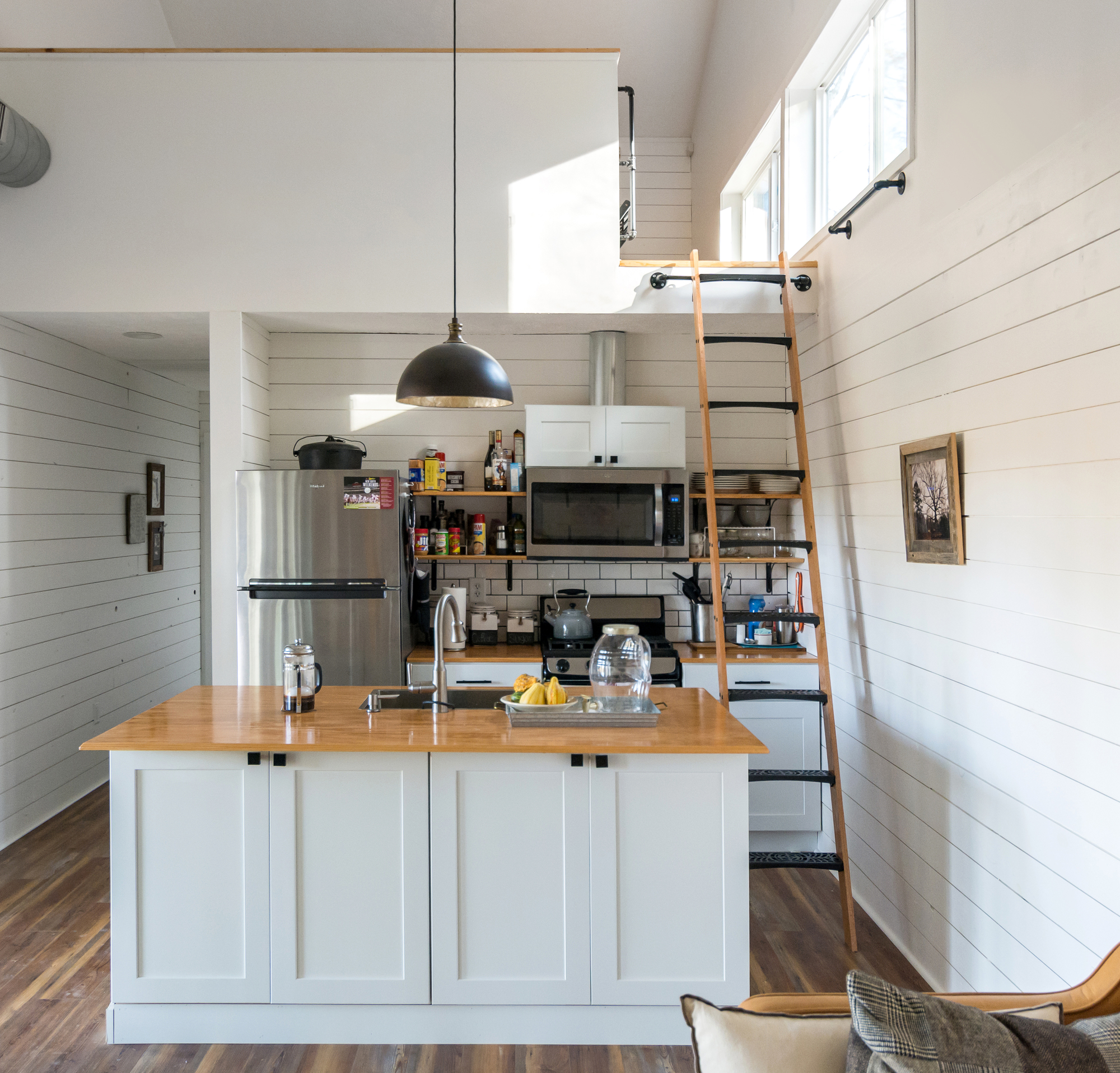 Kitchen with sleeping area above inside the tiny house