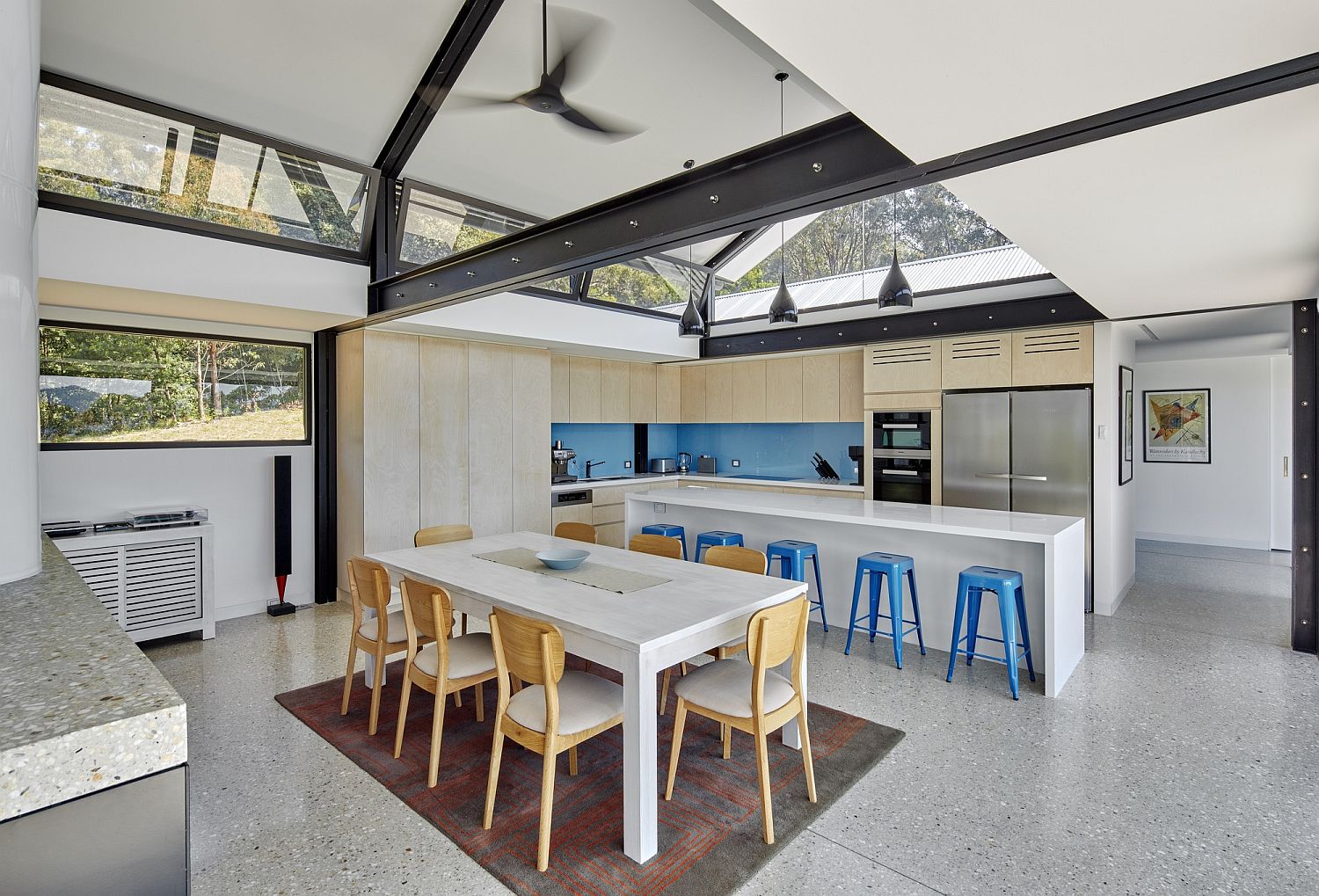 Open plan interior in white with kitchen and dining space