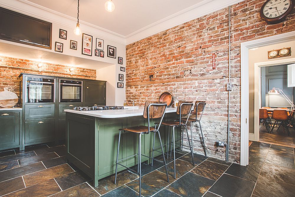 Unique-gallery-wall-for-industrial-kitchen-with-exposed-brick-walls-and-island-in-green