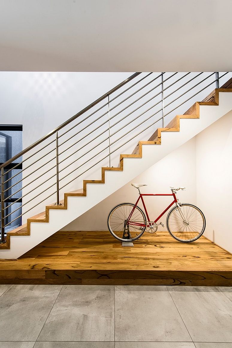 Beautifully lit space underneath the stairway for the bicycle