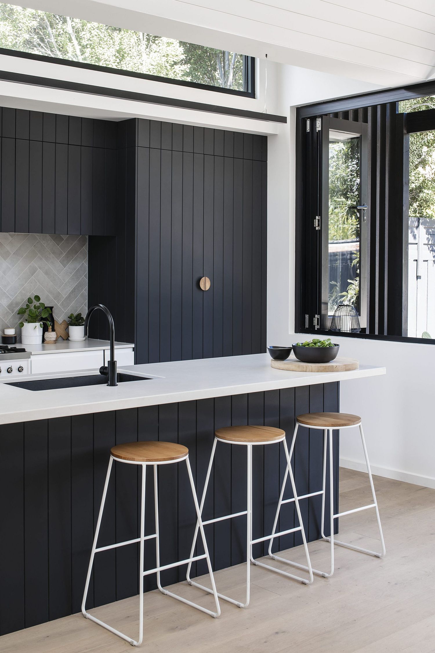 Charred and oiled cypress can be found in the modern white kitchen of the house as well