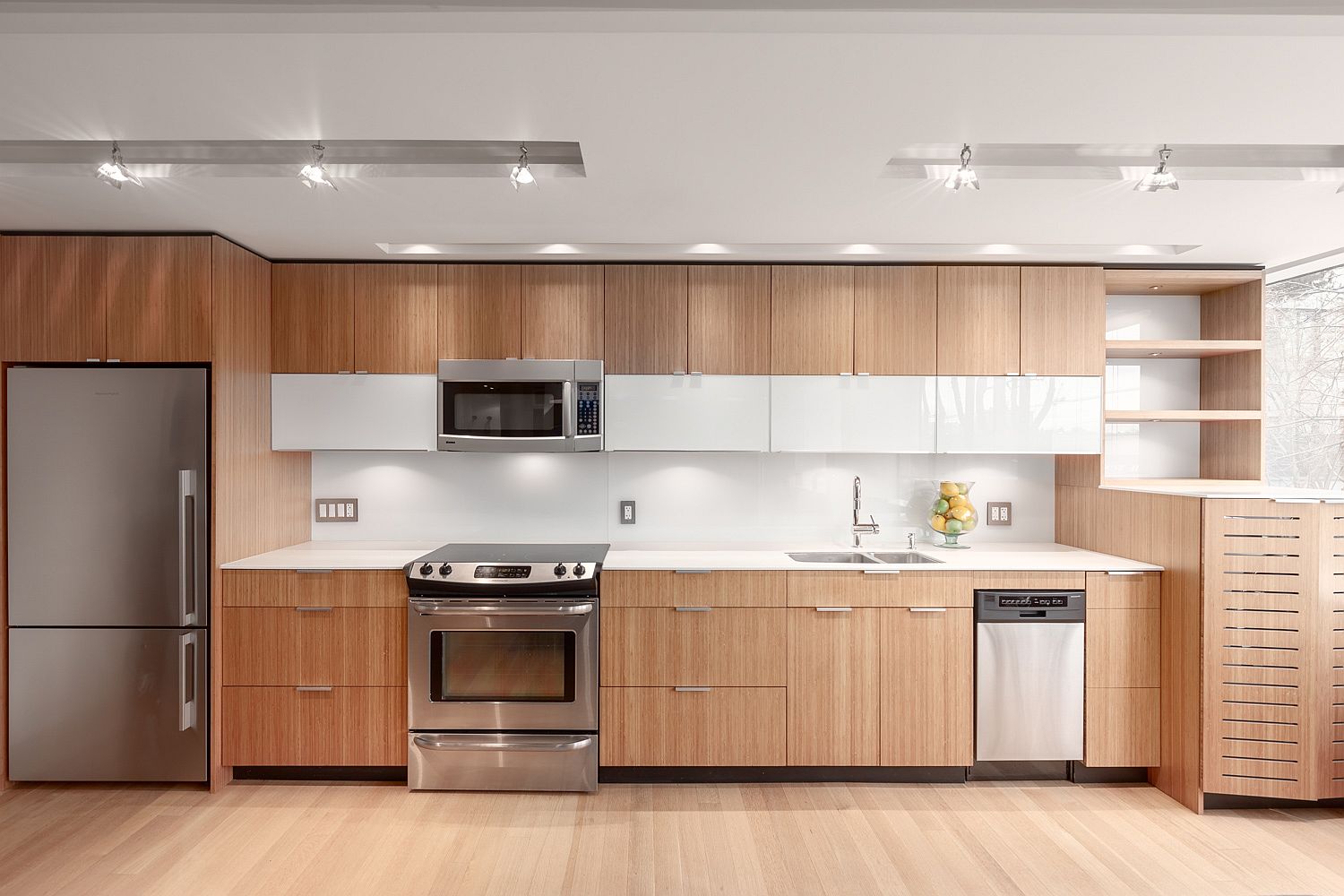 Custom millwork and smart appliances shape a space-savvy single wall kitchen inside the apartment