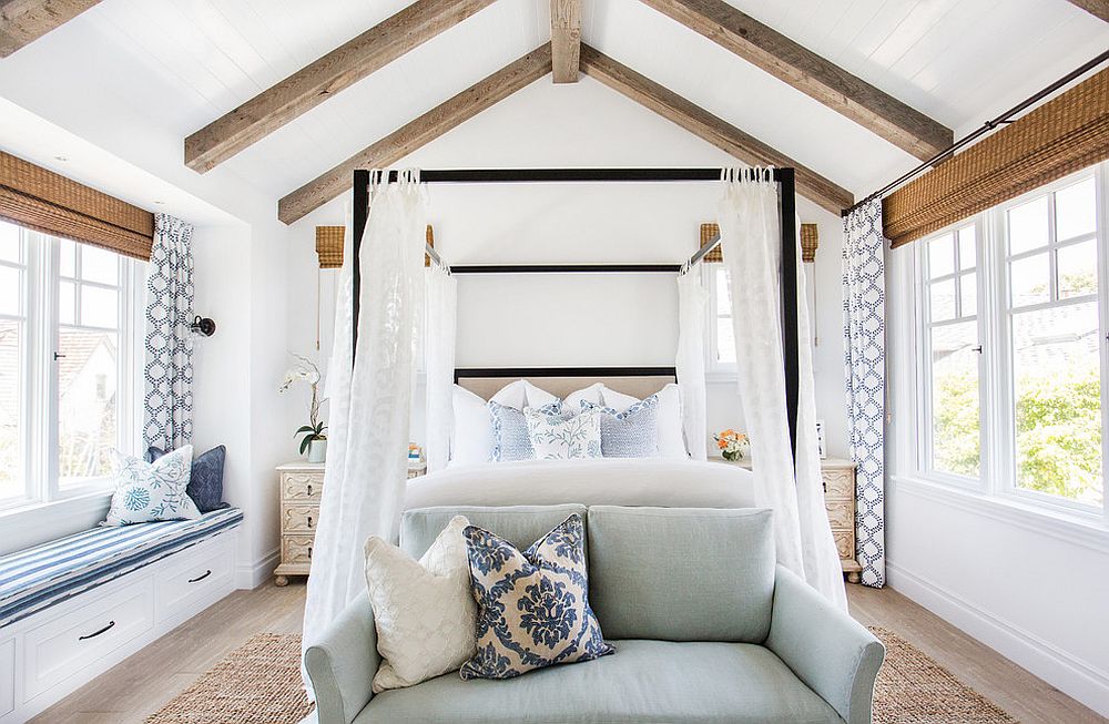 Four poster bed along with the slanting ceiling beams bring holiday vibe to this bedroom