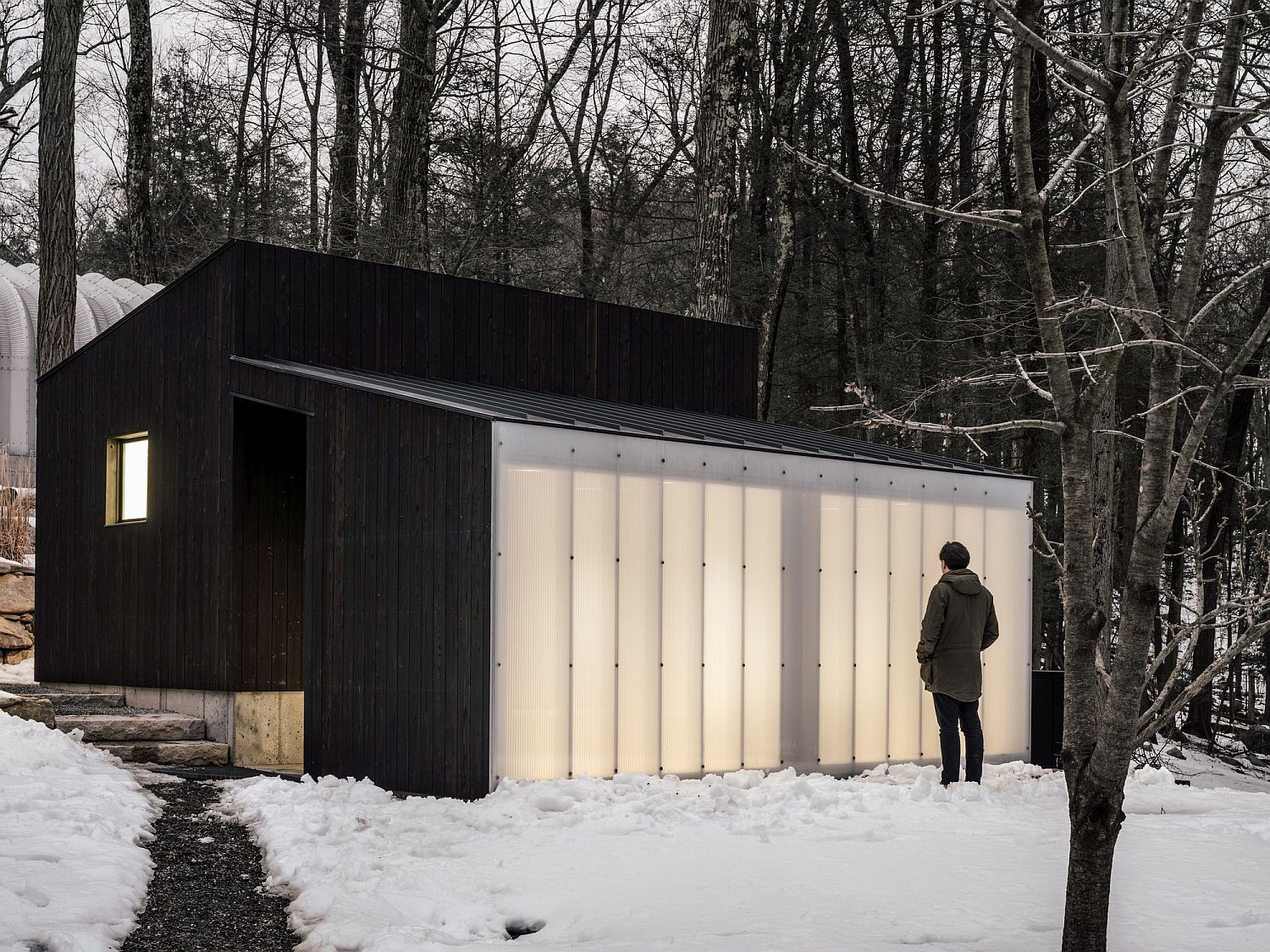 Small-Wooden-Pavilion-with-a-dark-wooden-exterior-and-polycarbonate-wall