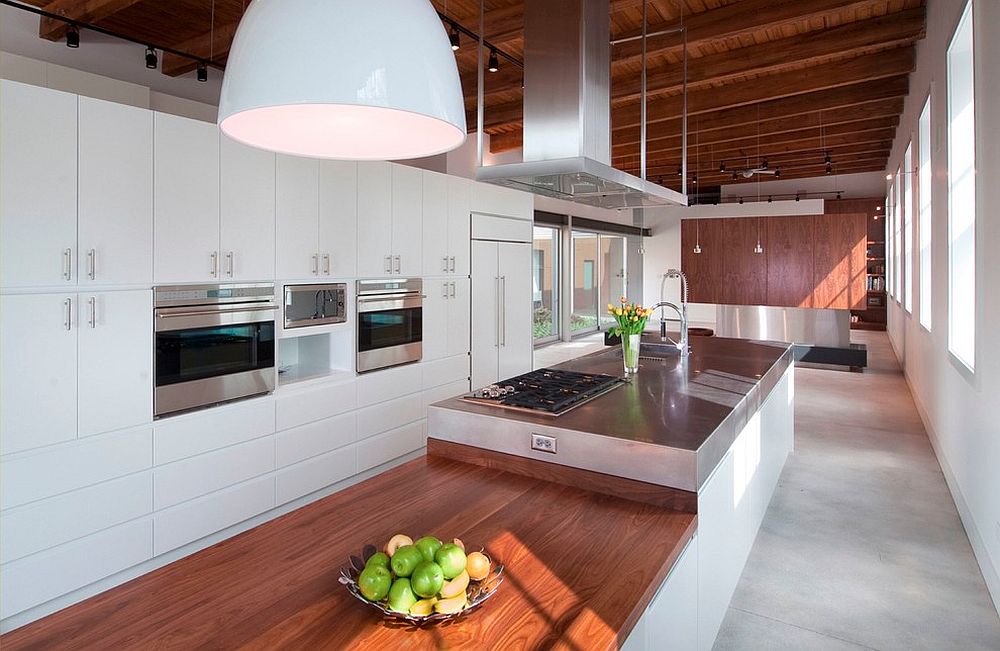 Spacious kitchen in white with wooden ceiling and countertops