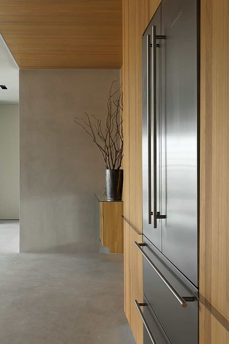 Large stainless steel fridge added to the dramatic wall of wood in kitchen