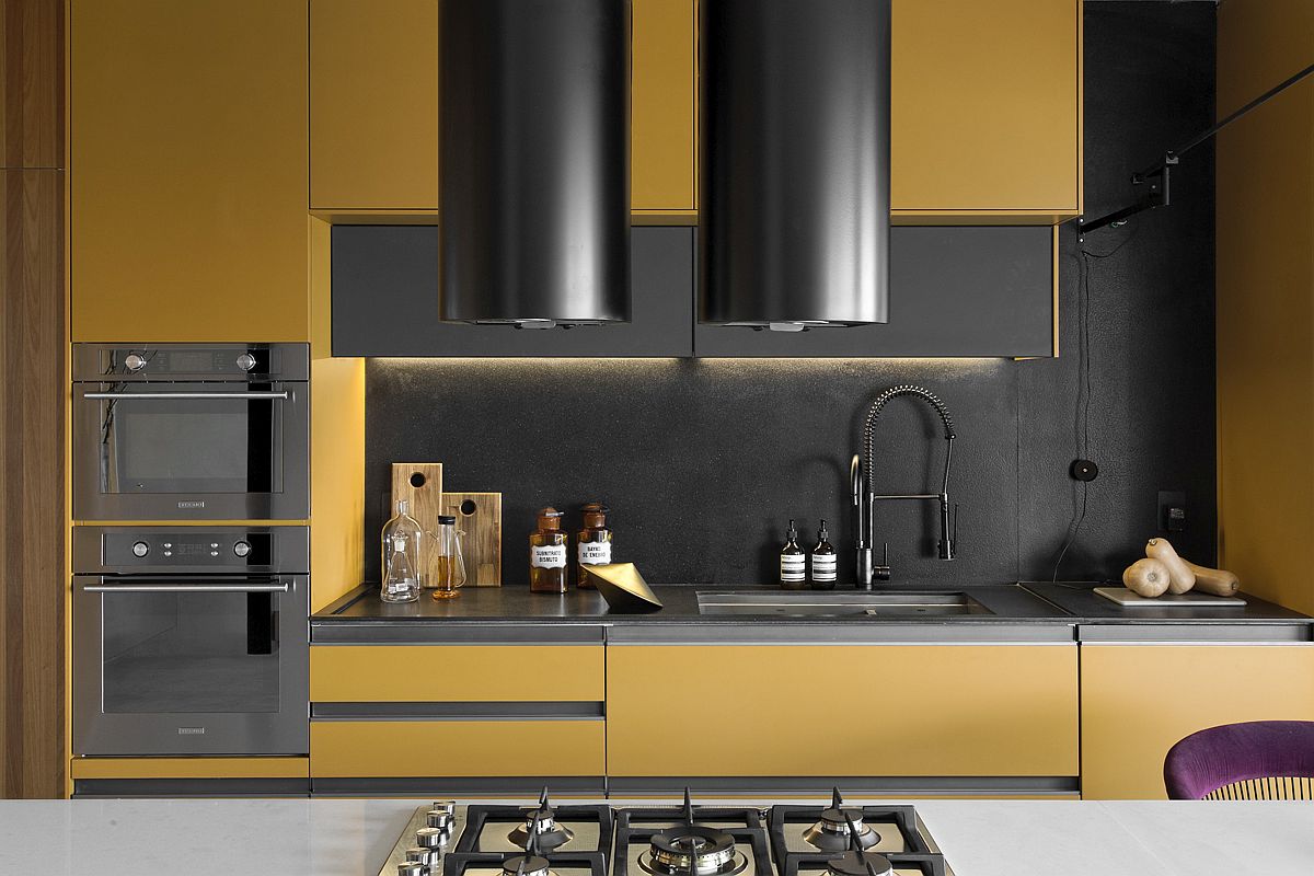 Mustard yellow and black shape the backdrop of the sophisticated kitchen