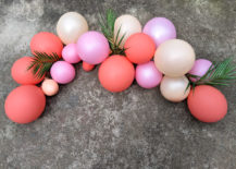 Pink-toned-balloon-arch-with-tropical-greenery-217x155