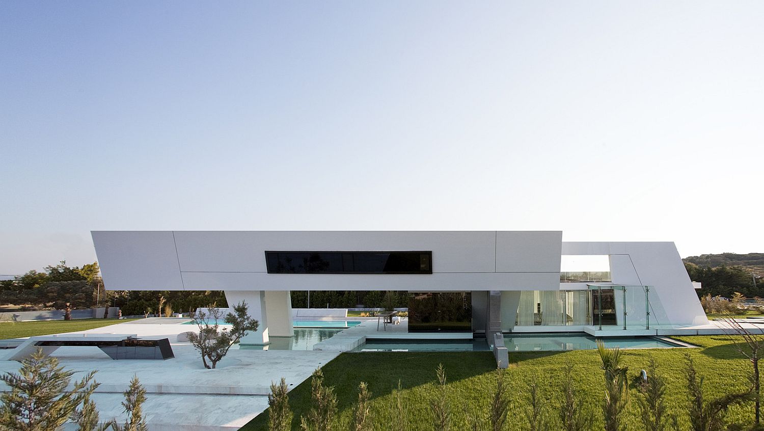 Polished white exterior of the home gives it a contemporary minimal appeal