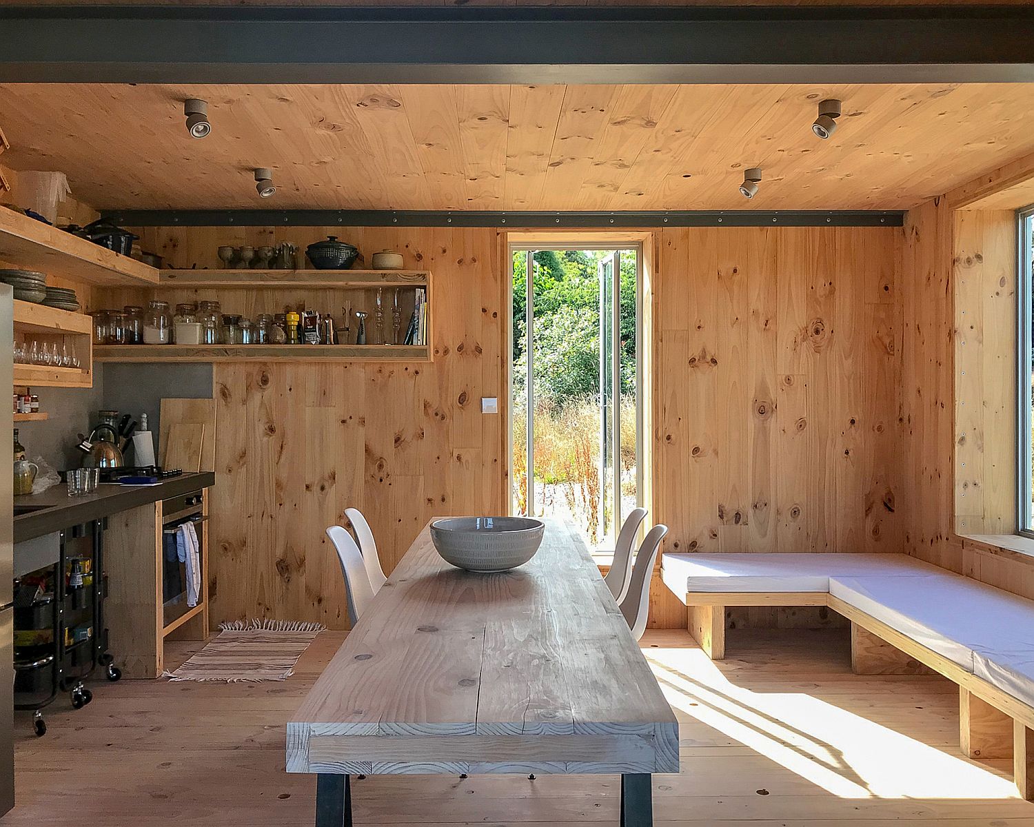 Small kitchen and tiny dining area of the cabin that opens up to the outdoors