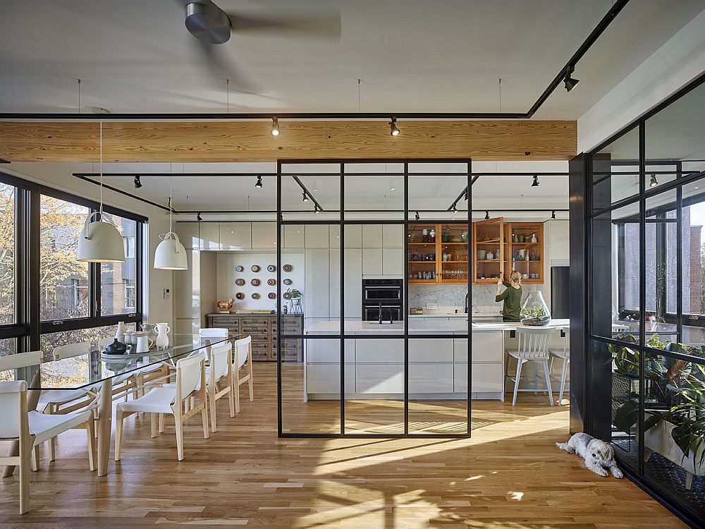 Smart glass walls and metallic frames delineate space inside the apartment