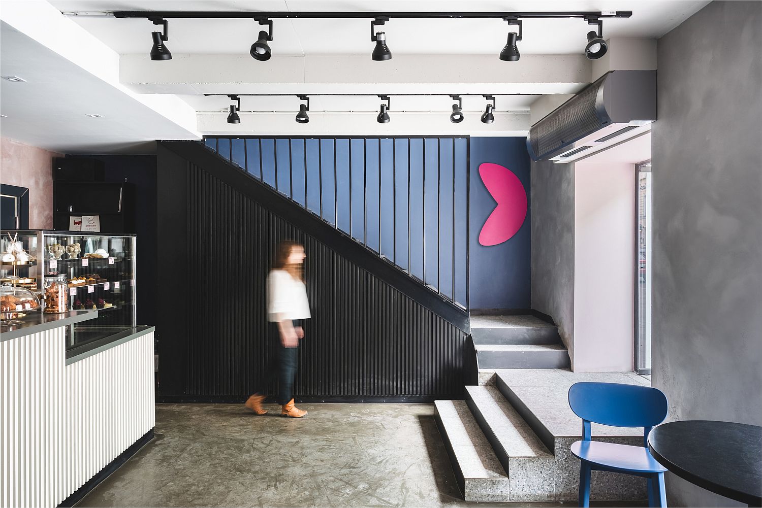 Black anchors the cafe takeaway zone with color and concrete