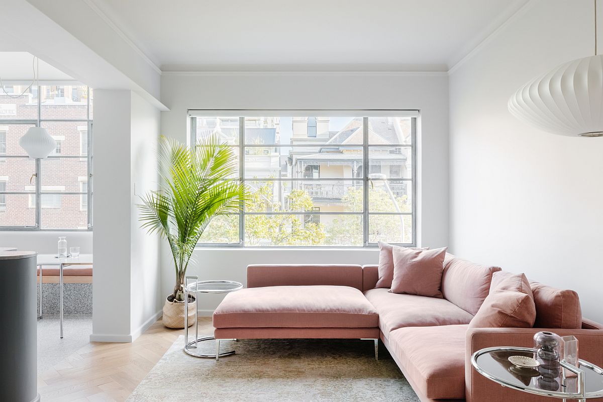 Fabulous sectional in pastel pink adds color to the white living room