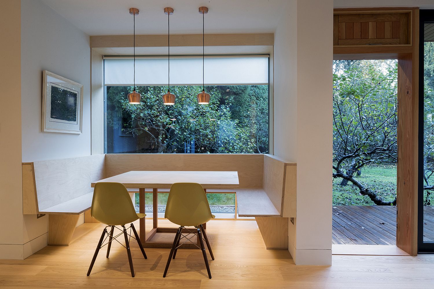 Floor-to-ceiling glass window brings light into the banquette styled dining area