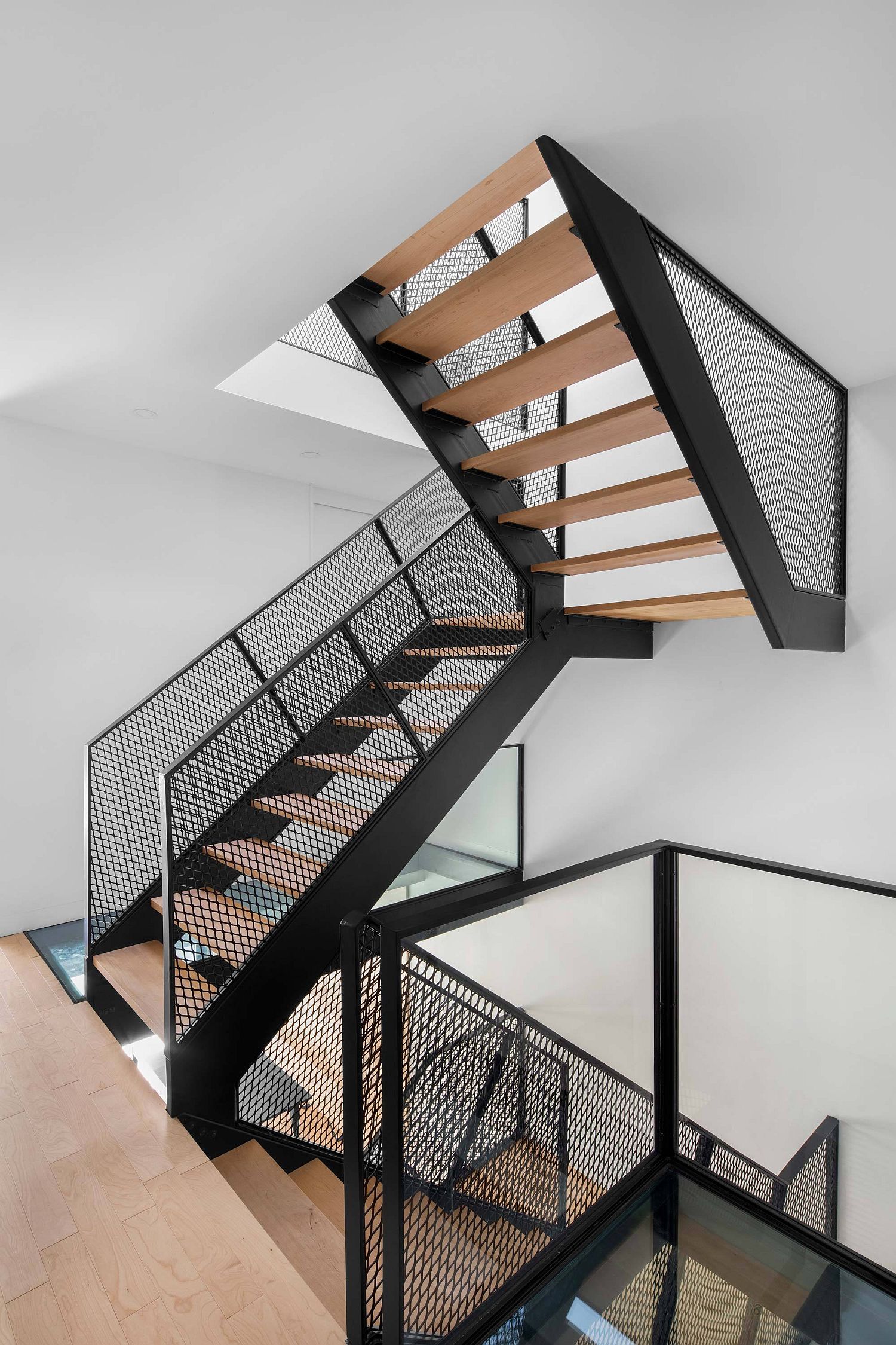 Metallic mesh and wood create a gorgeous central staircase in the house