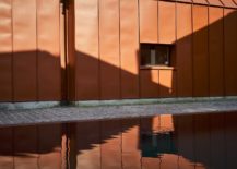 Metallic-orange-exterior-of-the-house-is-reflected-in-the-pool-217x155