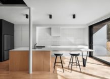 Minimal-kitchen-of-the-Montreal-home-in-wood-and-white-with-black-that-anchors-it-217x155
