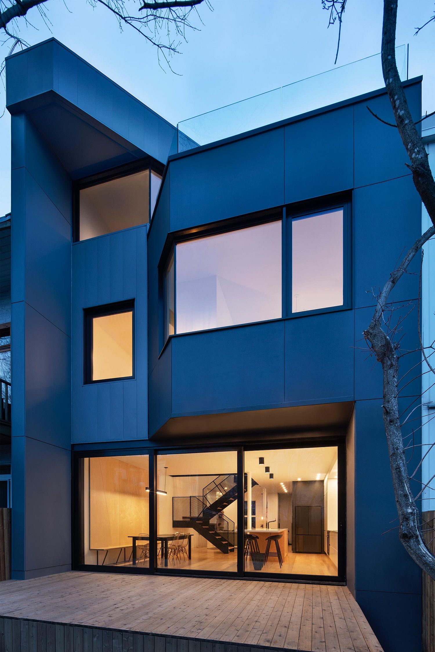 Sliding glass doors connect the interior with the wooden deck outside