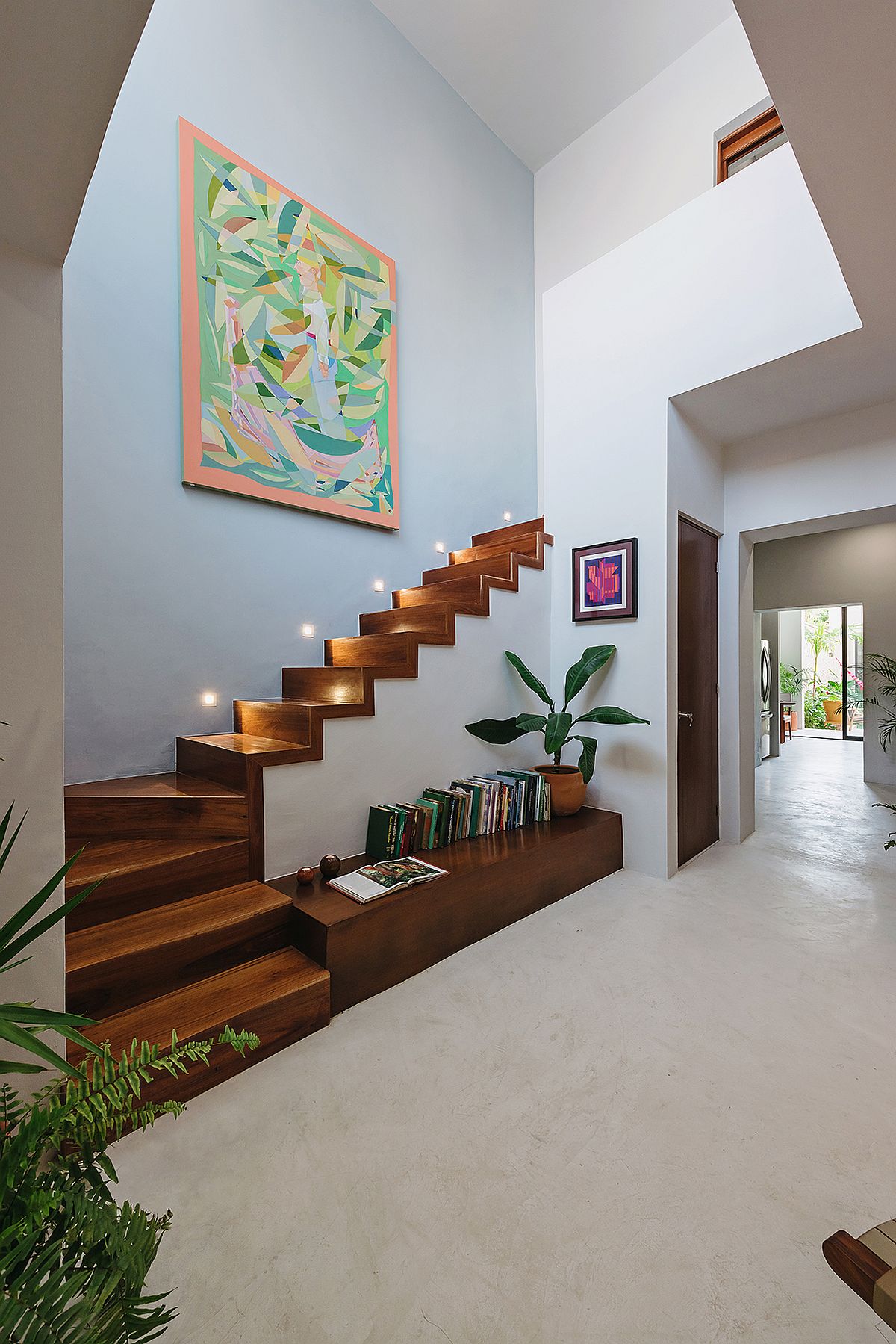 Beautifully illuminated wooden staircase with storage options beneath