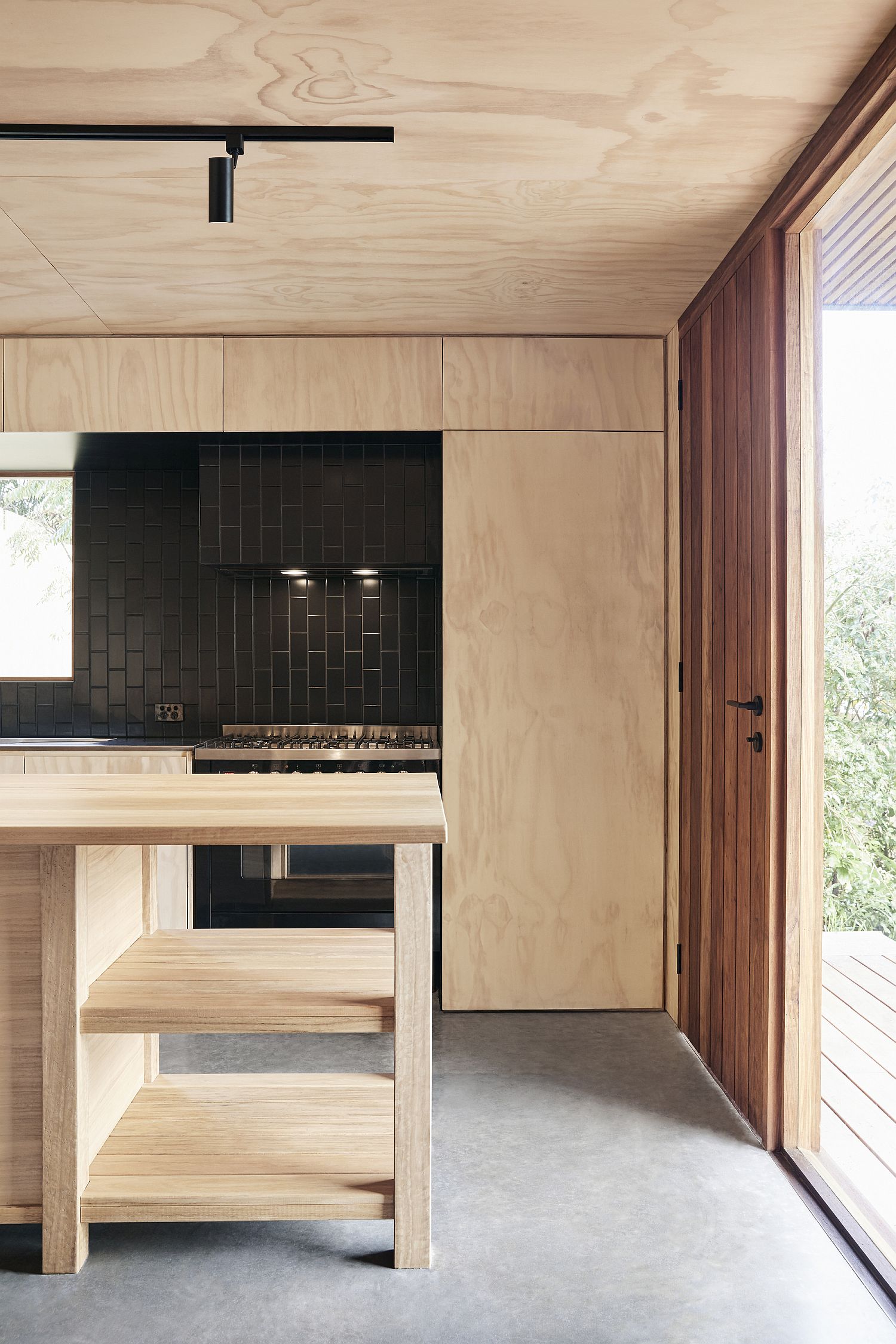 Black and wood along with polished concrete floors create a beautiful kitchen