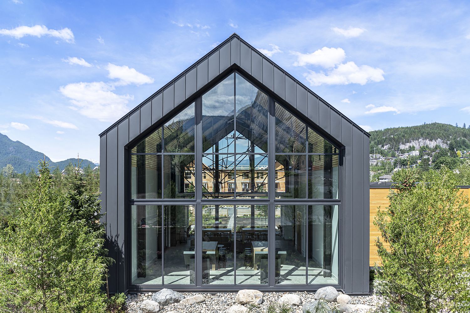 Dark metal panels along with glass create a delightful gable design