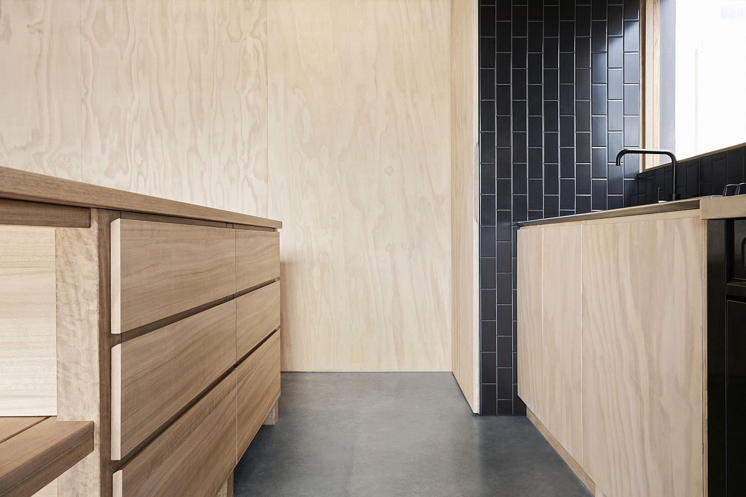 Dark tiles in black add contrast to the spacious and woodsy kitchen