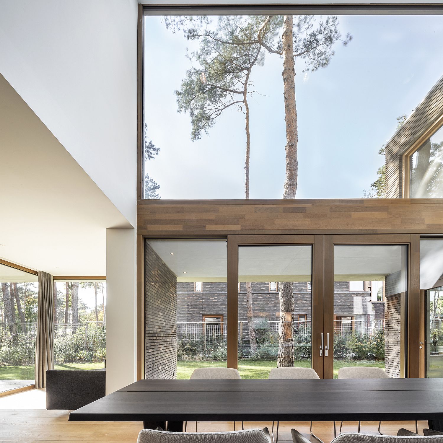 Floor-to-ceiling glass windows and timber frames make a bold statement