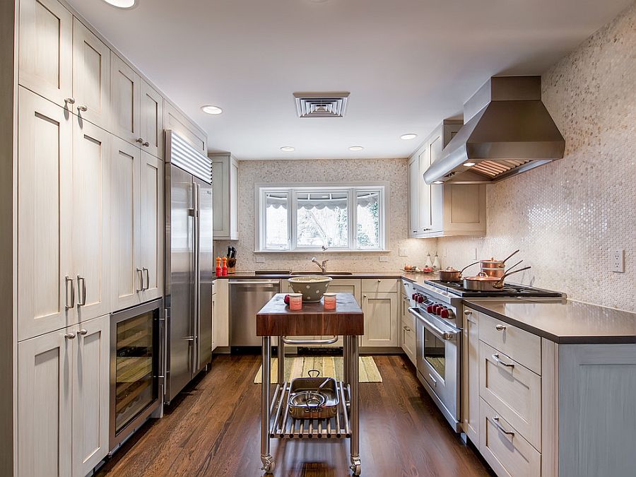 Glittering penny-tiled backdrop and narrow island on wheels for the small kitchen